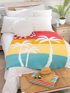 a bed with white pillows and palm trees on it