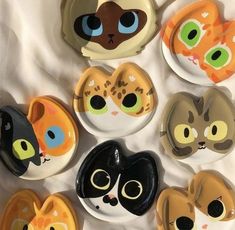 a bunch of plates that have different colored cats on them, one is black and the other is orange