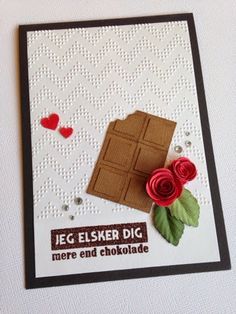 a close up of a piece of paper on a card with flowers and chocolates