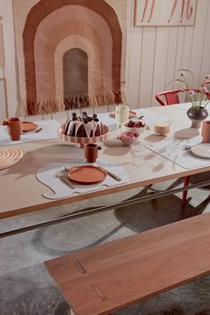 the table is set with plates, cups, and utensils for desserts