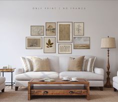 a living room filled with white furniture and pictures on the wall above it's coffee table