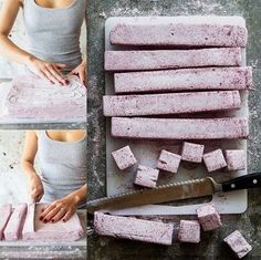 a woman is cutting up pink marshmallows with a knife