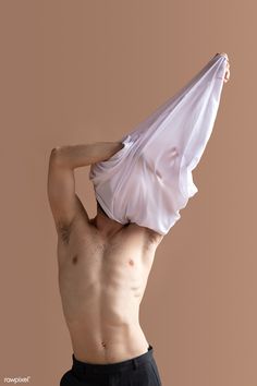 a shirtless man holding an umbrella up to his face with one hand and the other on top of his head