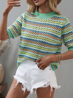 a woman in white shorts and a colorful sweater