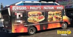 a food truck parked in front of a building with an advertisement on it's side