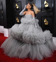 lady in grey gown standing on red carpet