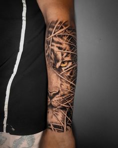 a man's arm with a tiger tattoo on the left side of his arm