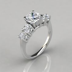 a three stone diamond ring on a gray background