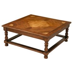 a square wooden table with an intricate design on the top and bottom, sitting against a white background