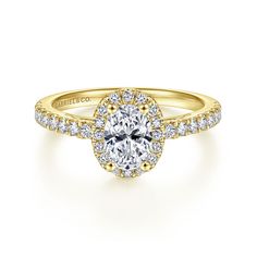 a yellow gold engagement ring with an oval center surrounded by small diamonds