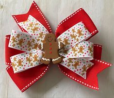 "GINGERBREAD MAN BOW WITH SMALL DOTS **The size of the pictured bow is 5 inches, but can be ordered in other sizes with the same shipping time. Hair bows may be made with a french barrette, an alligator clip (as shown), or a hair tie. ITEM DETAILS: *Ribbon Type: Base Layer- red with white stiching Top Layer-gingerbread men with dots Embellished with a gingerbread man *BOW DIMENSIONS: 4.5\", 5\", or 6\" *CLASP: French Barrette or Alligator Clip *Edges are heat sealed to prevent fraying *Assembled Gingerbread Man Hair Bows, Turkey Hair Bow, Thanksgiving Hair Bows, Woman Costumes, Disney Hair Bows, Vintage Christmas Sweaters, Disney Hair, Bow Ideas, Fabric Hair Bows