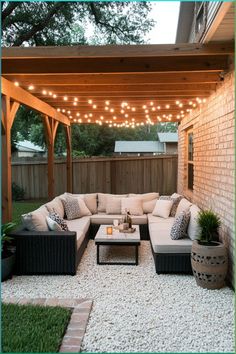 an outdoor living area with couches, tables and lights on the ceiling above it