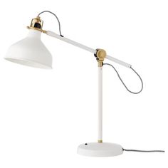 a white and gold desk lamp with a black cord attached to it, on a white background