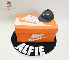 an orange nike box cake with a hat on top