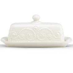 a white cake dish with an ornate design on it