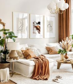 a living room filled with white furniture and lots of plants on top of the couch