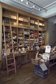 a store with wooden shelves filled with bottles and other items in baskets on the floor