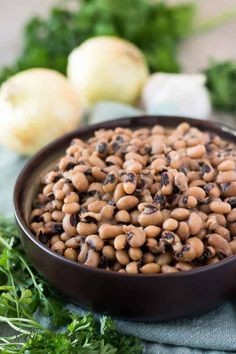 a bowl filled with black eyed peas next to onions and celery on a blue towel