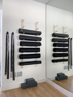 there are several yoga mats hanging on the wall and in front of them is a mirror