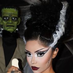 a woman with makeup on holding an ice cream cone in front of a green man