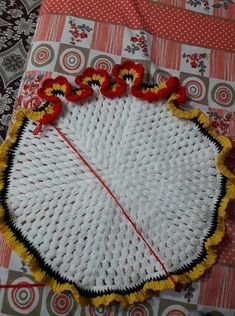 a white piece of cloth with red and yellow flowers on it, sitting on top of a table