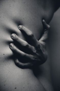 black and white photograph of a woman's stomach with her hands on her chest