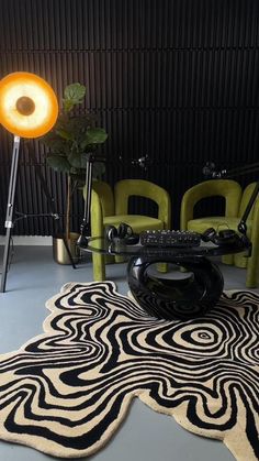 a living room with chairs and a rug on the floor