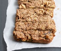 two slices of granola bread sitting on top of white paper next to each other