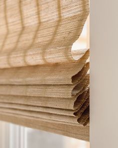 a close up view of a window with the blinds pulled back and folded over,