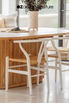 a wooden table with two white chairs around it