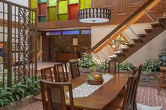 a dining room table with chairs and a bowl of fruit on it