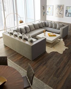 a large sectional couch sitting on top of a hard wood floor in a living room