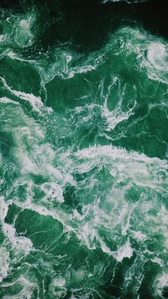 the water is green and white as it looks like foamy waves are coming in from the ocean