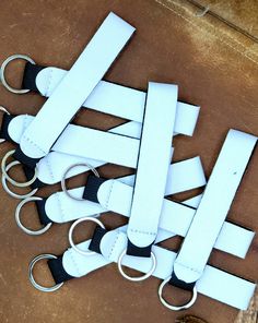 a bunch of white and black leather key fobs