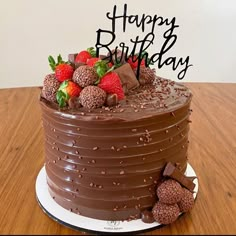 a chocolate birthday cake with strawberries on top