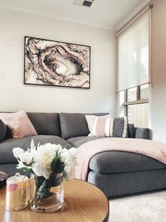 a living room filled with furniture and a painting on the wall