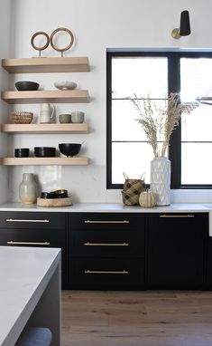 the kitchen is clean and ready to be used for cooking or baking, with black cabinets and gold pulls