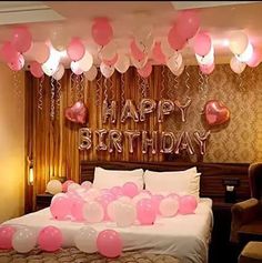 a bedroom decorated for a birthday with balloons and streamers