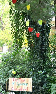 the tree of knowledge is good and evil sign in front of some trees with hearts hanging from them