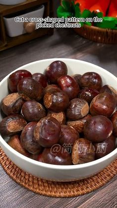 a bowl filled with chestnuts on top of a wooden table