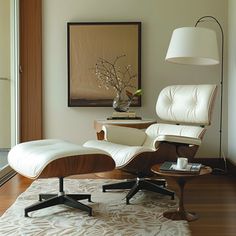 an eames chair and ottoman in front of a window with a painting on the wall