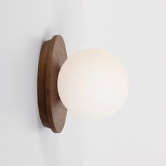 a light that is on the wall next to a white wall mounted object with a wooden frame