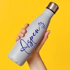 a person holding a white water bottle with blue writing on it and the word agnes written on it