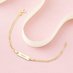 A classic engravable tag id bracelet for baby girls and boys that features an elegant figaro chain. This bracelet is crafted from genuine 14k yellow gold, a material that is safe for your baby with sensitive skin. This classic bracelet makes for a beautiful gift for a baby or toddlers special birthday. Gift box included with purchase. Personalized Yellow Gold Rectangular Name Bracelet, Personalized Rectangular Yellow Gold Name Bracelet, Classic 14k Gold Hypoallergenic Name Bracelet, Classic Hypoallergenic 14k Gold Name Bracelet, Elegant Hypoallergenic Nameplate Bracelet, Classic Gold Name Bracelet Hypoallergenic, Classic Gold Hypoallergenic Name Bracelet, Classic Name Bracelet With Curb Chain As A Gift, Classic Adjustable Gold Bracelet With Name