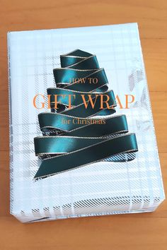 a gift wrap wrapped in green ribbon on top of a white box with the words, how to gift wrap