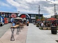 people are sitting at tables in front of a building with graffiti on the side of it