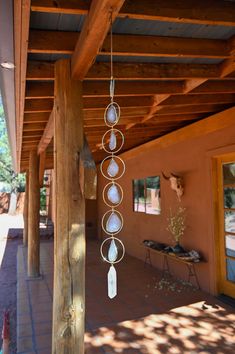 an outdoor area with wooden pillars and white beads hanging from it's side wall