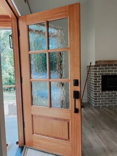 a wooden door with frosted glass in front of a brick fire place and fireplace