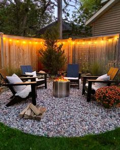 a fire pit surrounded by chairs and lights in a back yard with gravel around it