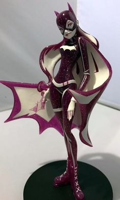 a figurine that is on top of a black and white base with purple accents